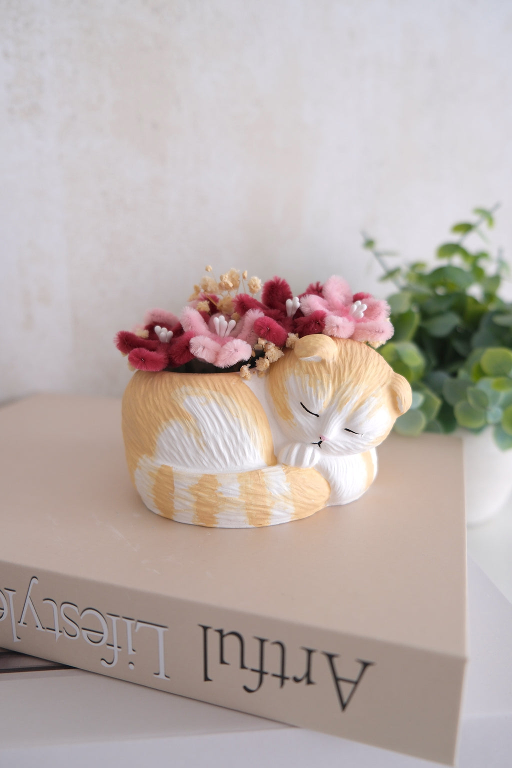 Statuette de chat endormi avec des fleurs