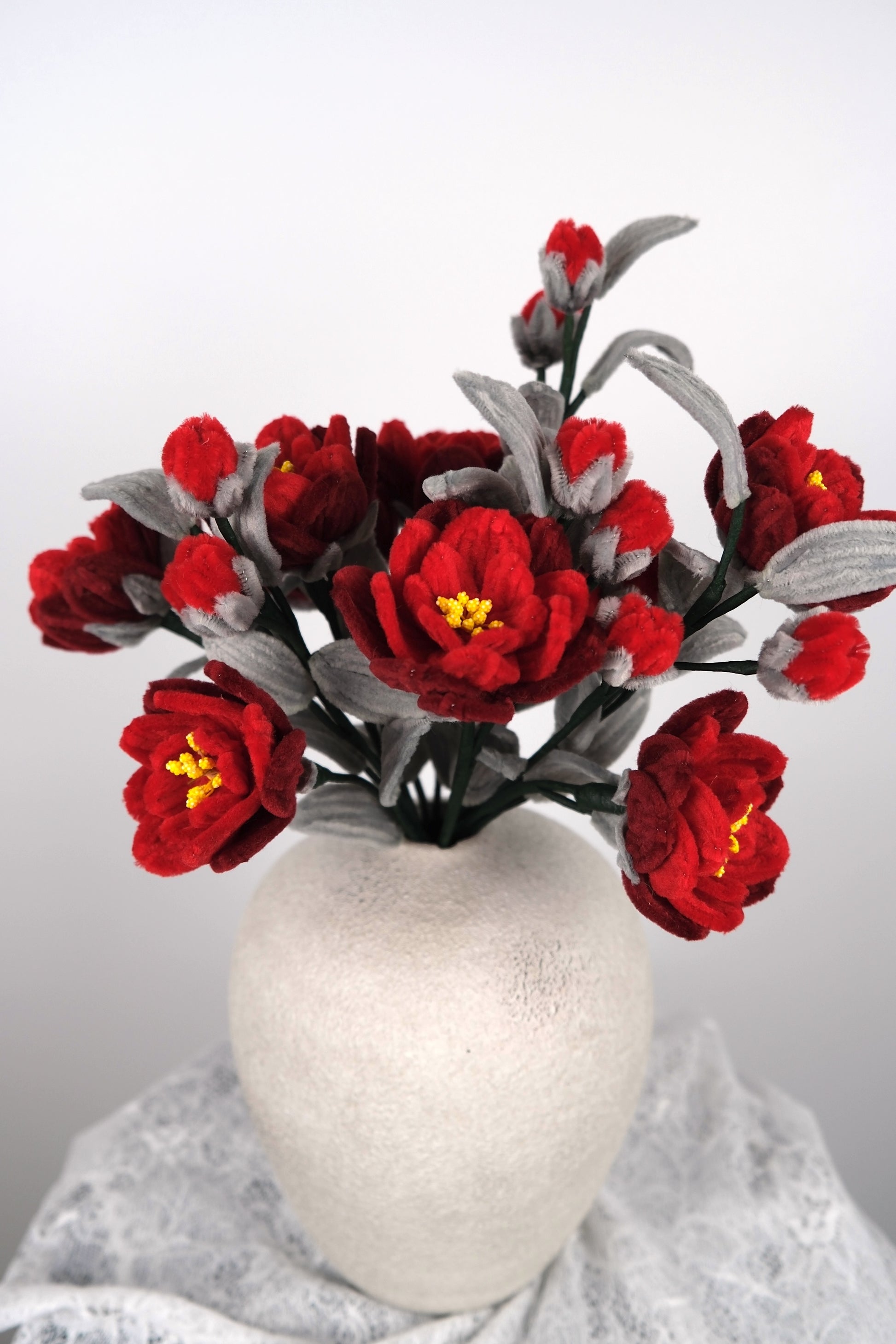 Rode en grijze bloemen in vaas