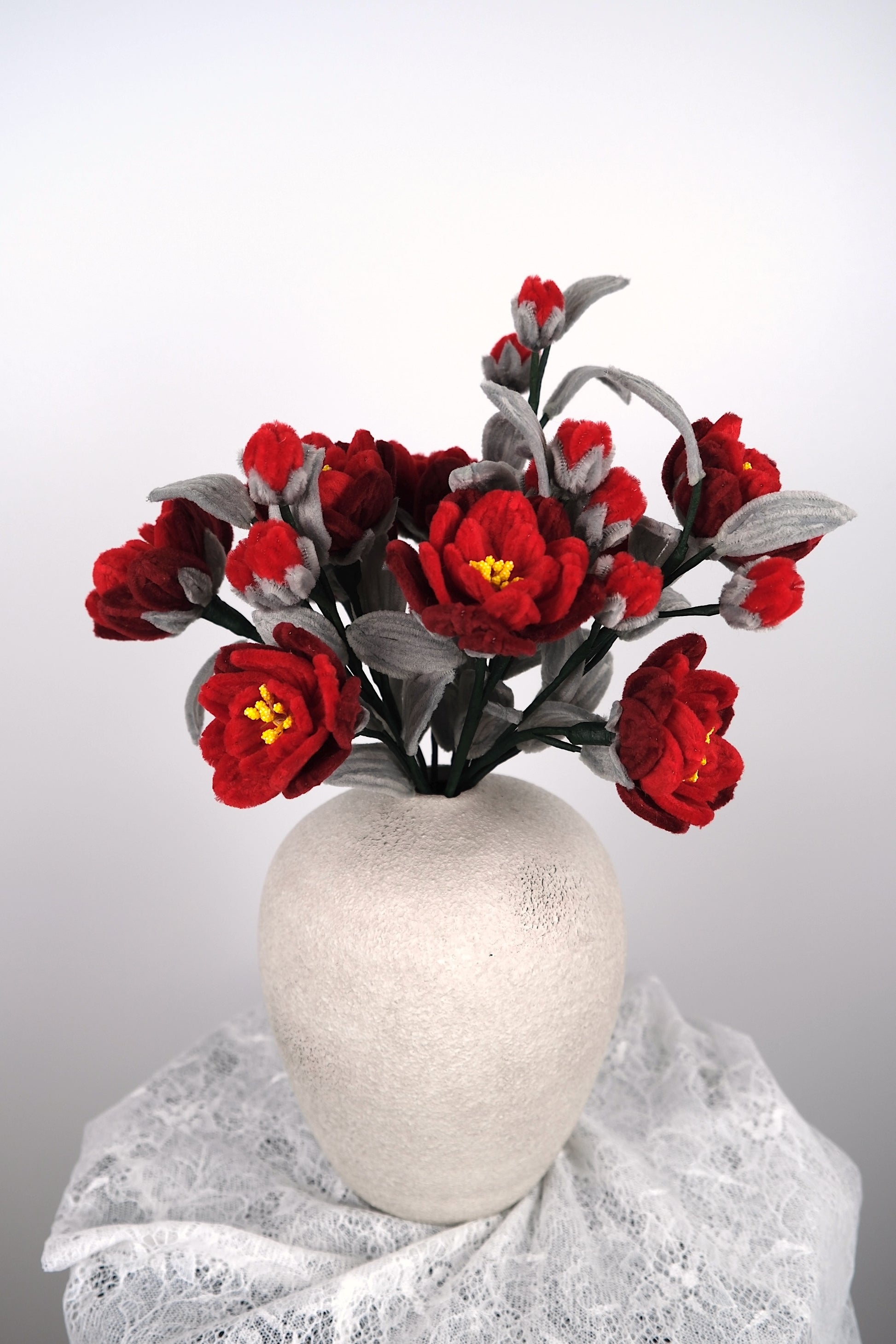 Rode en grijze bloemen in vaas